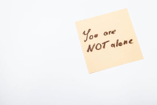 You are not alone inspirational note on yellow sticker memo