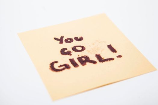Empowering women feminist note on yellow paper saying you go girl