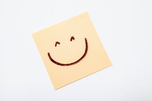 Happy smiley face drawn on yellow post-it notes