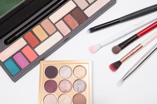 Top view close up of eyeshadow palettes and makeup brushes