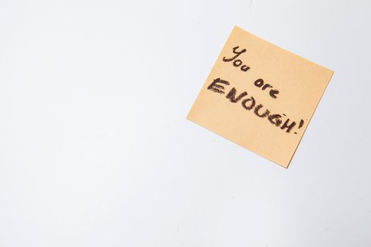 You are enough text written on yellow sticky note