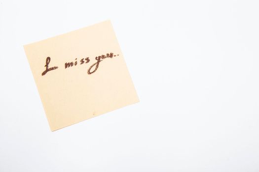 I miss you handwritten on yellow memo paper