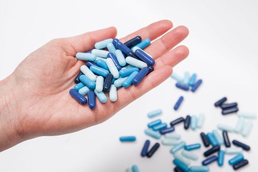 Cropped close up of blue medicament pills in the hand of unrecognizable person