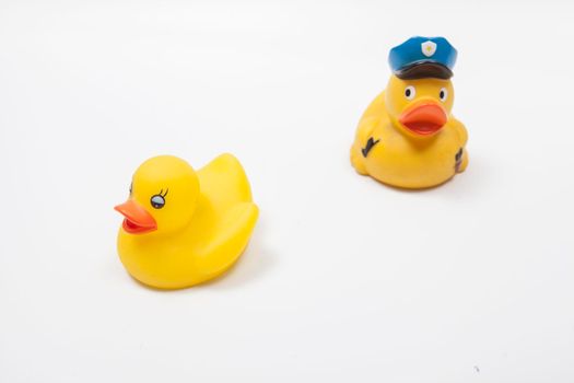 Rubber duck policeman chasing rubber duck criminal. Law enforcement concept