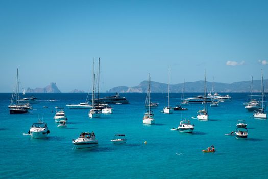 Boats anchored in Cala Saona with Es Vedra in the background