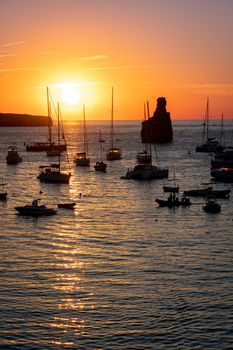 Summer sunset in Cala Benirras with anchored boats