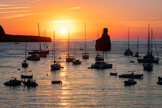 Summer sunset in Cala Benirras with anchored boats