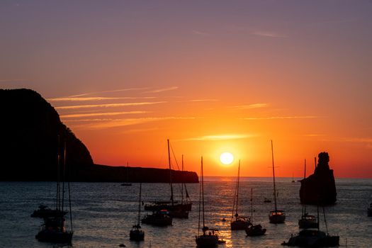 Summer sunset in Cala Benirras with anchored boats
