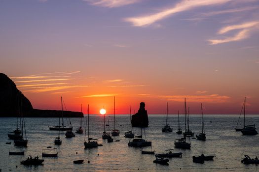 Summer sunset in Cala Benirras with anchored boats