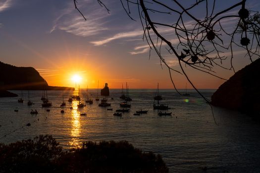 Summer sunset in Cala Benirras with anchored boats