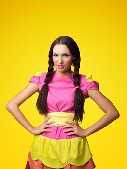 Funny girl in doll costume look serious on yellow background