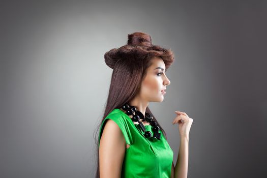Beauty brunette woman portrait with hair style hat in green suit look at light
