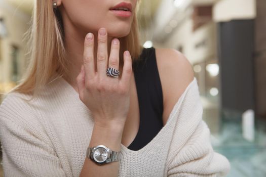 Cropped close up of a woman wearing expensive ring and watch