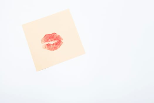 Red lipstick kiss on yellow memo paper piece