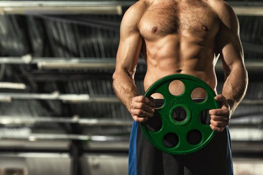 Time to work! Cropped shot of a shirtless man with hot sexy toned muscular strong torso holding barbell weight plate copyspace body masculinity power strength weightlifting bodybuilding fitness