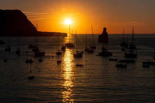 Summer sunset in Cala Benirras with anchored boats