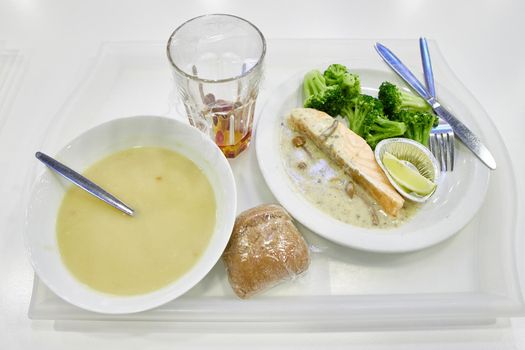 Mushroom soup puree and fish with vegetables on plates. Healthy food without meat.