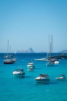 Boats anchored in Cala Saona with Es Vedra in the background