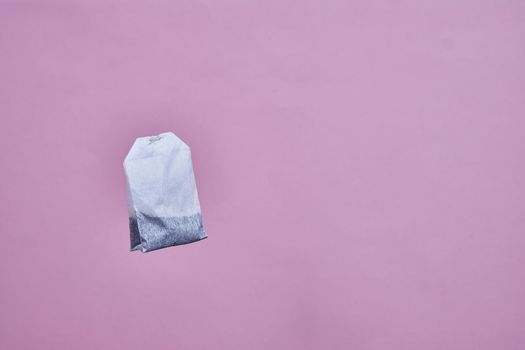 a tea bag spinning on a pink background.