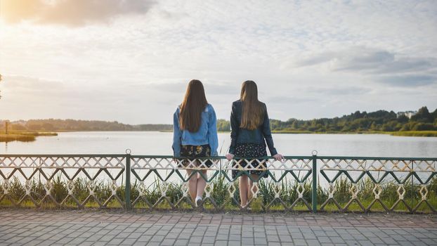 Two friendly friends sit and cuddle by the lake