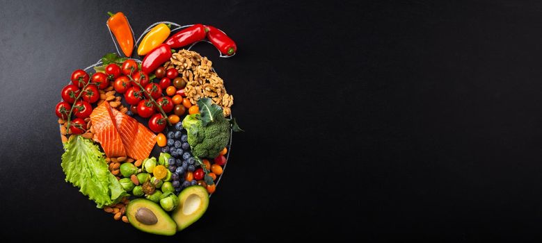 Healthy diet and nutrition for heart and cardiovascular system, healthy food, fruit and vegetables arrangement in realistic heart shape on black chalk board top view composition with copy space.