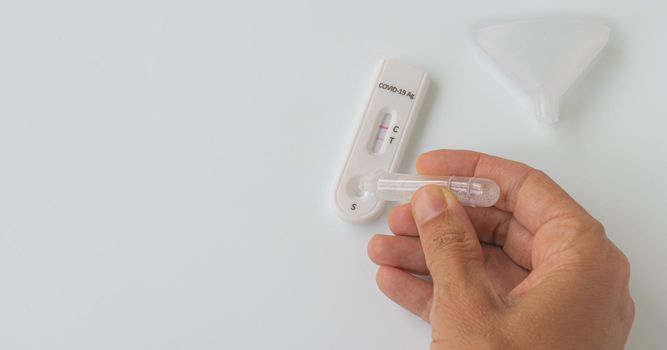 Making Coronavirus Covid-19 antigen test with positive result on white background.