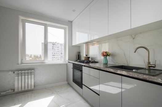 Interior of white and grey small modern domestic kitchen furniture