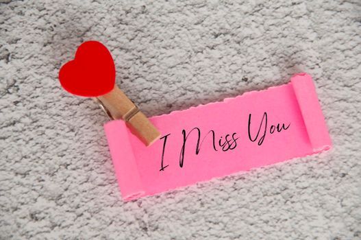 I miss you text on torn pink paper. Romance and relationship concept.