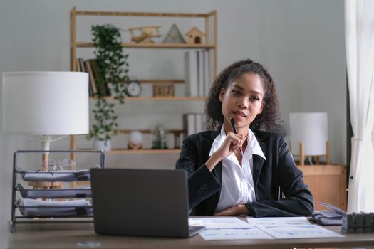 Creative young african american woman working on laptop in her studio,Doing accounting analysis report real estate investment data, Financial and tax systems concept..