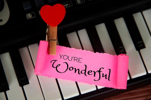 You are wonderful text on torn pink paper with keyboard background. Romance and relationship concept.