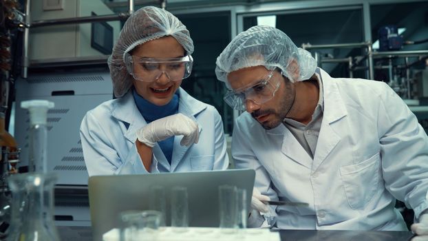 Two scientist in professional uniform working in laboratory for chemical and biomedical experiment