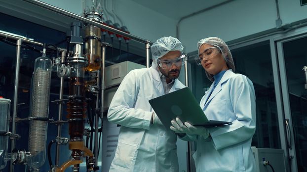 Two scientist in professional uniform working in laboratory for chemical and biomedical experiment