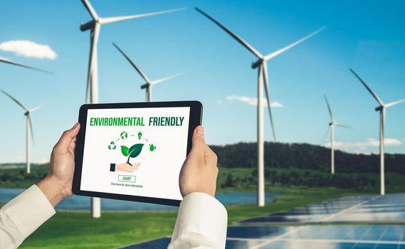 Green business transformation for environment saving and ESG business concept. Businessman using tablet to set corporate goal toward environmental friendly management and alternative clean energy use.