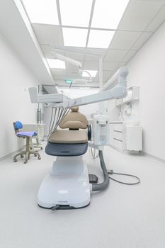 patient chair in Interior of white modern dentistry medical room with special equipment