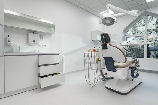 Interior of white modern dentistry medical room with special equipment