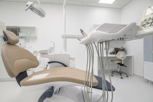 patient chair in Interior of white modern dentistry medical room with special equipment