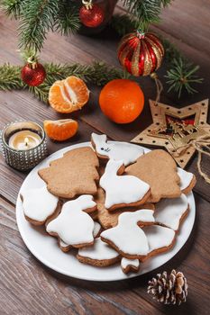 Delicious homemade Christmas cookies in the form of a rabbit and a Christmas tree on a wooden table decorated with New Year's decor.