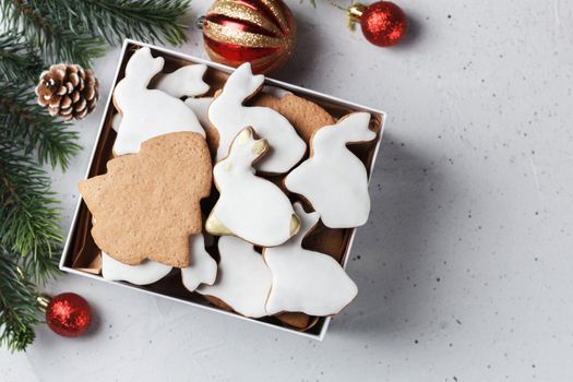 A box of Christmas cookies in the form of a rabbit and a Christmas tree on the table with New Year's decor. copy space