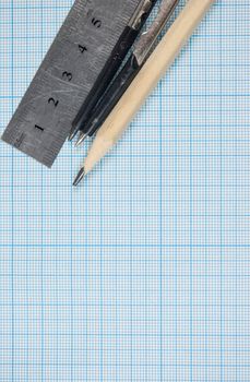 Still life photo of engineering graph paper with pencil, compasses and metal ruler blank to add your own design