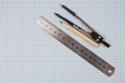 Still life photo of engineering graph paper with pencil, compasses and metal ruler blank to add your own design