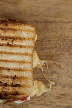 big sandwich with ham, cheese, tomatoes on toasted bread over wood table. Top view