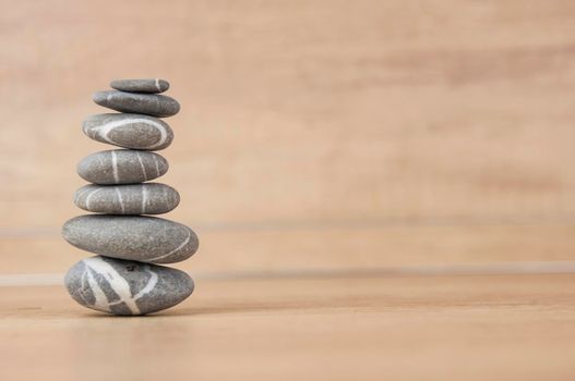 Stack of pebble stones on a wooden surface. Concept zen, spa, relax.