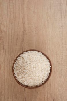 Bowl of white rice on wood table. top view