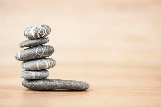 Stack of pebble stones on a wooden surface. Concept zen, spa, relax.