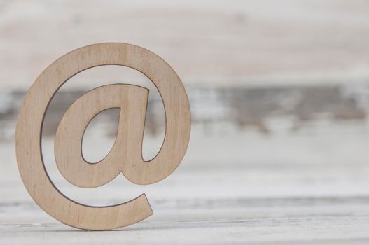 An email sign on a old white wood lies on a vintage wooden table. Concept e-mail message letter. Top view with copy space