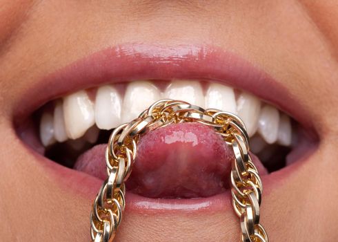 Beauty sexy woman lips smile and gold chain on tongue close-up shot
