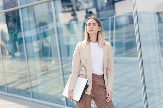 Woman with laptop near modern office center