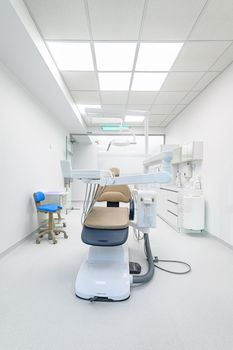 Interior of white modern dentistry medical room with special equipment