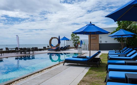 Amari Huahin Thailand, Aerial view at the pool with sunbeds, luxury resort with swimming pool and sunbed by the ocean at a luxury resort