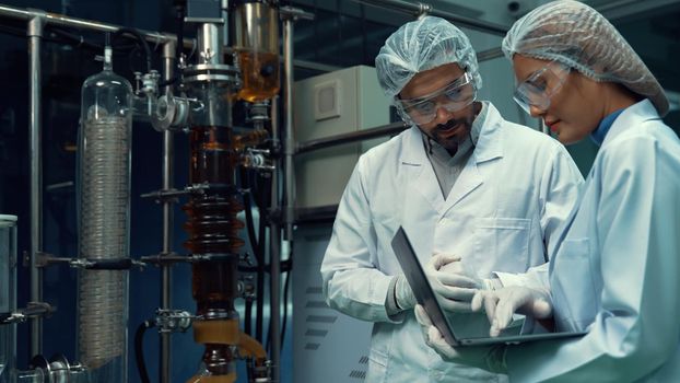 Two scientist in professional uniform working in laboratory for chemical and biomedical experiment